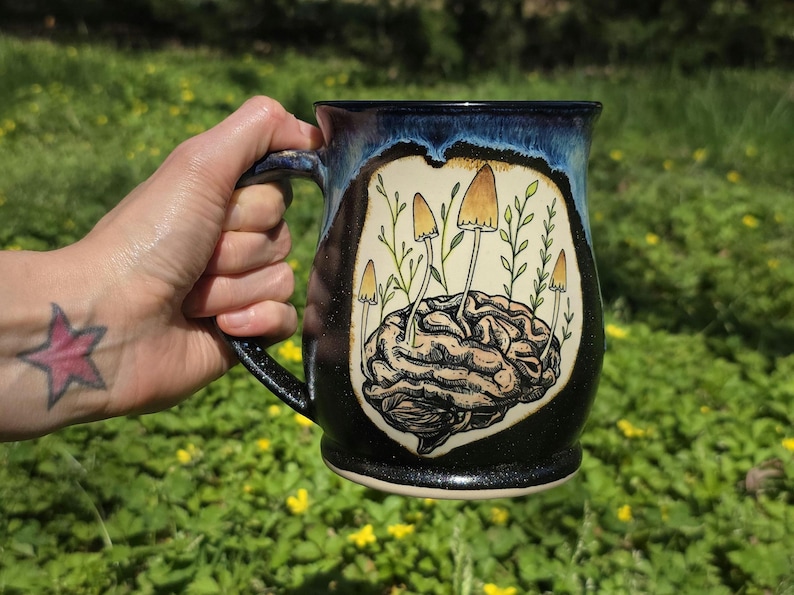 May include: A set of three ceramic mugs with a speckled, matte finish. The mugs are in shades of cream, light gray, and dark gray. Each mug has a simple, minimalist design and a rounded handle.