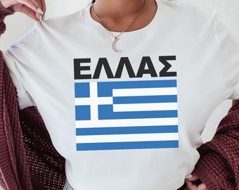 May include: White t-shirt with a blue and white Greek flag and the word "ΕΛΛΑΣ" in black lettering.