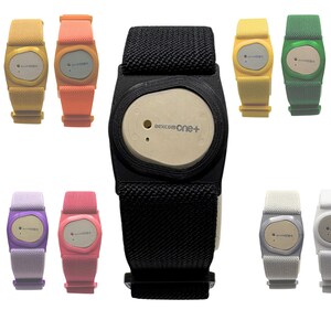 May include: A collection of glucose monitor holders with adjustable fabric straps in various colours including red, yellow, orange, black, green, blue, light blue, purple, pink, grey, and white, each featuring a central device labelled Dexcom one+.