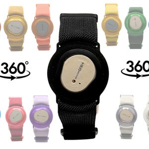 May include: A black fabric armband featuring a central circular holder for a Dexcom One+ continuous glucose monitor sensor. The image displays a variety of coloured bands in red, yellow, orange, blue, pink, purple, green, and white options.