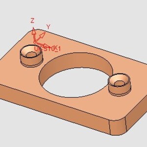 Könnte beinhalten: Ein rechteckiger Block aus hellem Braun mit zwei runden Löchern. Der Block hat ein größeres Loch in der Mitte und ein kleineres Loch auf der rechten Seite. Der Block ist so ausgerichtet, dass das größere Loch zum Betrachter zeigt.