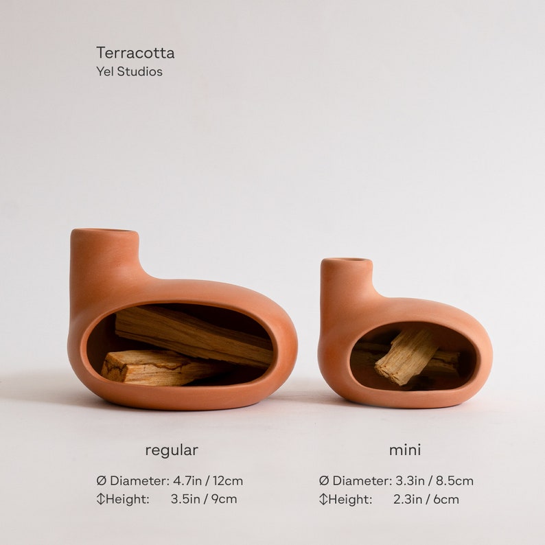 May include: Two terracotta ceramic incense holders, one regular and one mini. The regular holder is 4.7 inches in diameter and 3.5 inches tall. The mini holder is 3.3 inches in diameter and 2.3 inches tall. Both holders have a unique, rounded shape with a hole in the side for incense sticks.