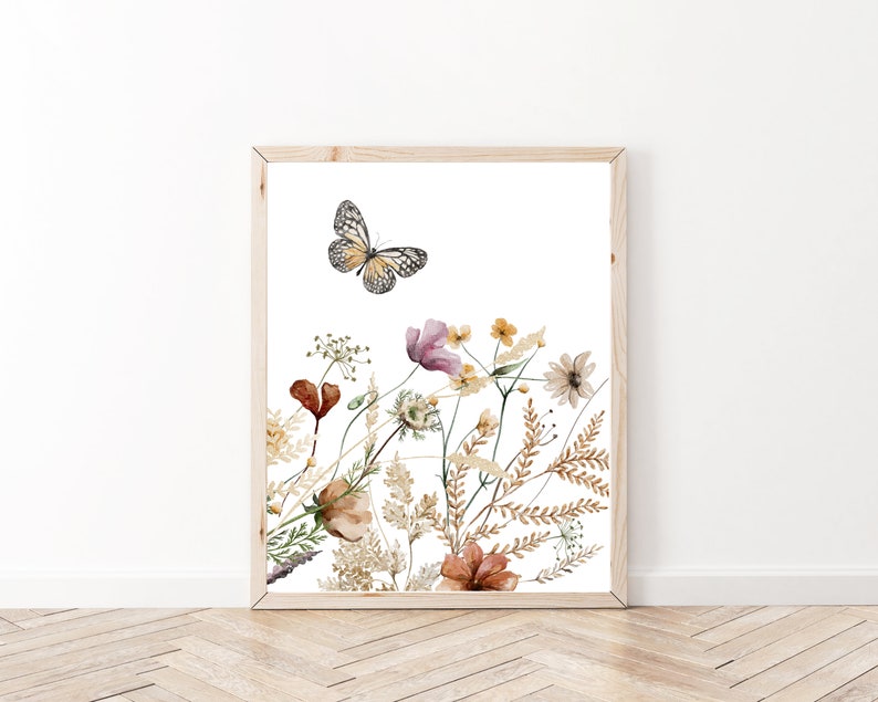 May include: A watercolor painting of a butterfly flying over a bouquet of wildflowers in shades of brown, pink, and yellow. The flowers are arranged in a cluster, with the butterfly flying above them. The background is white.