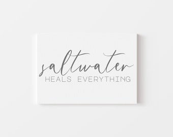 May include: A white canvas print with the text "saltwater heals everything" in gray cursive script.