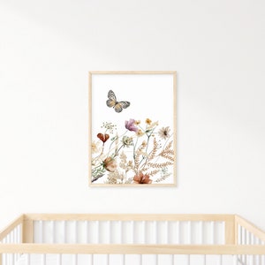May include: A framed print of a watercolor painting featuring a butterfly flying over a cluster of dried flowers in shades of brown, pink, and yellow.