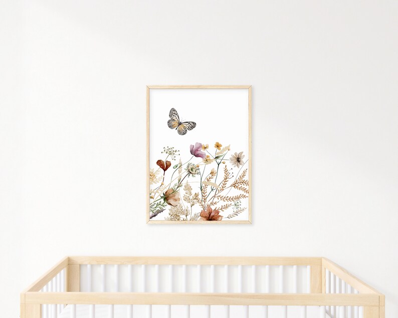 May include: A framed print of a watercolor painting featuring a butterfly flying over a cluster of dried flowers in shades of brown, pink, and yellow.