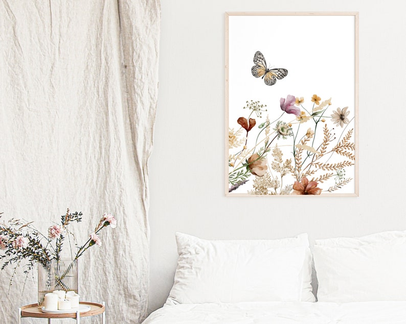 May include: A framed print featuring a watercolor illustration of a butterfly flying over a bouquet of dried flowers in shades of brown, pink, and white.