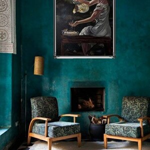 May include: A painting of a woman in a white dress pouring water from a pitcher into a basin. The painting is framed in a silver frame and is hanging on a teal wall.