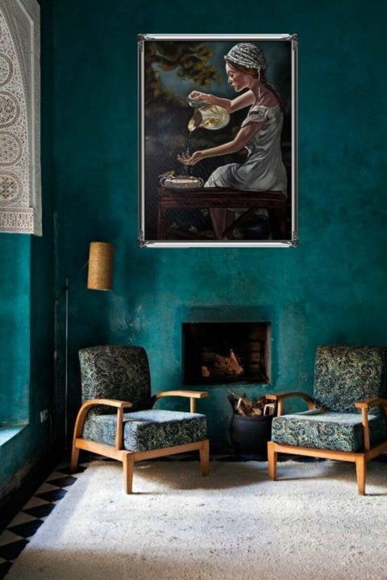 May include: A painting of a woman in a white dress pouring water from a pitcher into a basin. The painting is framed in a silver frame and is hanging on a teal wall.