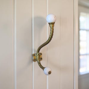 Vintage-Garderobenhaken aus Messing – gedrehtes Design mit weißen Keramikknöpfen