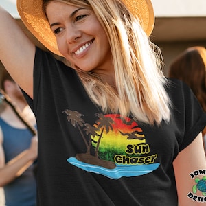 May include: Black t-shirt with a graphic of a sunset over a tropical island with palm trees and the text "Sun Chaser".