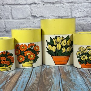 Vintage stacking Japanese tin kitchen canister set with bold yellow and orange flower design