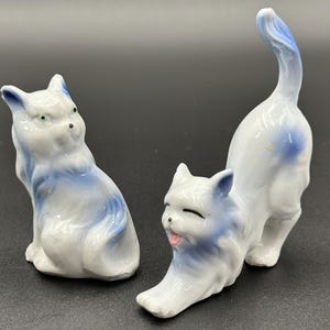 Stare ceramiczne figurki kotów w kolorach białym i niebieskim