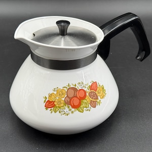May include: White glass coffee pot with a black handle and lid. The pot features a floral design with orange, brown, and yellow flowers. The lid is stainless steel, and the handle is black plastic.