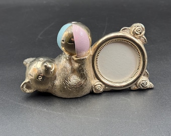 Hucha vintage de los años 80 con forma de oso reclinado plateado, bola y marco de fotos.