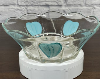 May include: A clear glass bowl with a scalloped rim and blue and green painted floral designs. The bowl is sitting on a white pedestal.