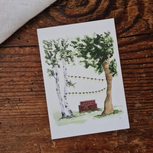 Rotes Sofa unter Bäumen A6 Postkarte Gemütlichkeit Lichterkette Einladung zum Gemütlichsein