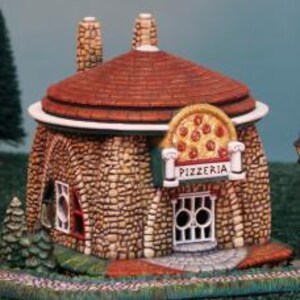 May include: A miniature stone building with a red roof and a pizza-shaped window. The building has a sign that says "Pizzeria".