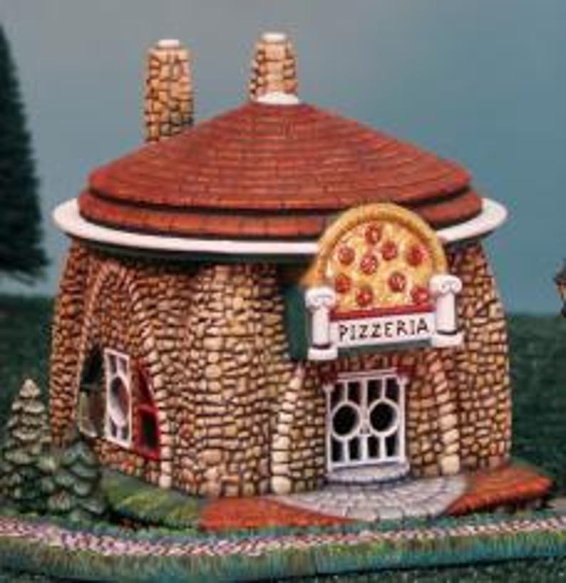 May include: A miniature stone building with a red roof and a pizza-shaped window. The building has a sign that says "Pizzeria".