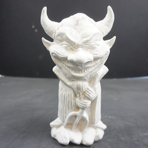 May include: White ceramic figurine of a devil with horns, a pointed beard, and a mischievous grin. The devil is holding a pitchfork in its right hand.