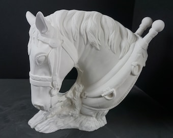 May include: A white horse head sculpture with detailed mane, bridle, and decorative elements. The sculpture features a harness and two decorative posts on the side. The horse head is a bust, with a textured base.