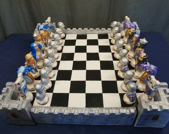 May include: A chess set with a white and black chequered board, featuring castle-shaped end pieces and silver and blue painted chess pieces.