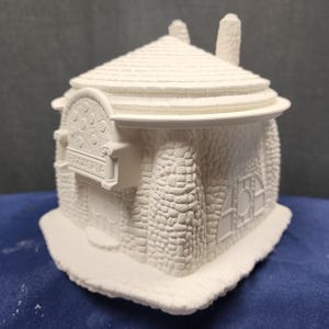 May include: White ceramic model of a small building with a stone facade and a sign that reads "Pizzeria".