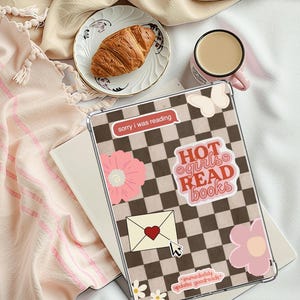 May include: A clear tablet case with a brown and white checkered pattern and various stickers. Stickers include the text "HOT girls READ books", a pink flower, and a speech bubble that says "sorry I was reading".