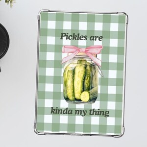 May include: A green and white checkered background with a glass jar of pickles tied with a pink ribbon. The text "Pickles are kinda my thing" is printed below the jar.