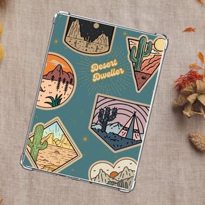May include: A teal blue phone case with a desert theme. The case features cacti, mountains, and a sunset. The text "Desert Dweller" is printed on the case.