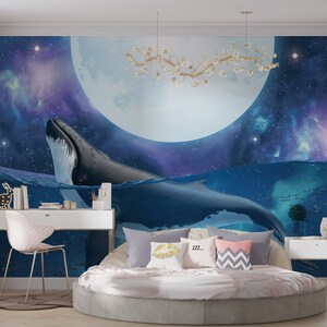 May include: A bedroom with a mural featuring a whale breaching the surface of the water, a full moon, and stars. The mural is painted on a wall behind a round bed with pillows and a white duvet.