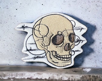 Skissartad anatomisk dödskalle broderad lapp