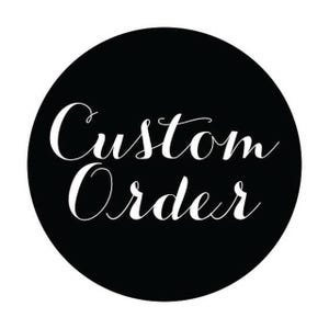 May include: A black circular graphic with the words "Custom Order" in elegant white cursive script. The text is centered within the circle, creating a clean and simple design. The contrast between the black background and white text makes the words stand out.