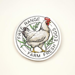Broderad lapp med färska ägg och kyckling från gården. Rustik gård.