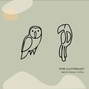 Puede incluir: Diseño de arte de línea de un búho y un tucán. El texto "THE CUTTERIST Special Design Cutters" está debajo de las imágenes.