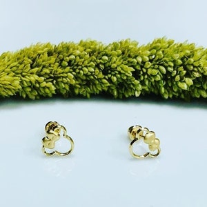 May include: A pair of gold-tone earrings with a cloud-shaped design. Each earring features three small round beads.