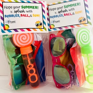 May include: Two clear plastic bags filled with summer themed party favors. Each bag contains a pair of sunglasses, a beach ball, a bubble wand, and a lollipop. The bags are decorated with a tag that says "Hope your summer is splash with bubbles, ball, & sun!"