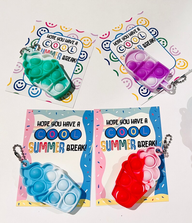K&ouml;nnte beinhalten: Vier bunte Pop-it-Fidget-Spielzeuge in Form von Eiswaffeln mit Schl&uuml;sselanh&auml;ngern. Jedes Spielzeug hat eine andere Farbkombination und ist mit einer Karte versehen, auf der steht: "Ich hoffe, du hast coole Sommerferien!"