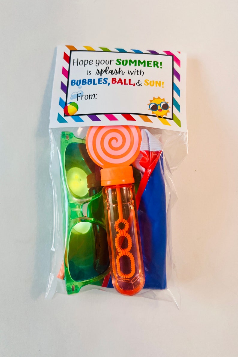 May include: A clear plastic bag filled with summer-themed party favors. The bag contains a pair of green sunglasses, a bubble wand, a blue beach ball, and a pink and orange lollipop. The bag has a tag that reads "Hope your SUMMER! Is splash with BUBBLES, BALL, & SUN! From:"