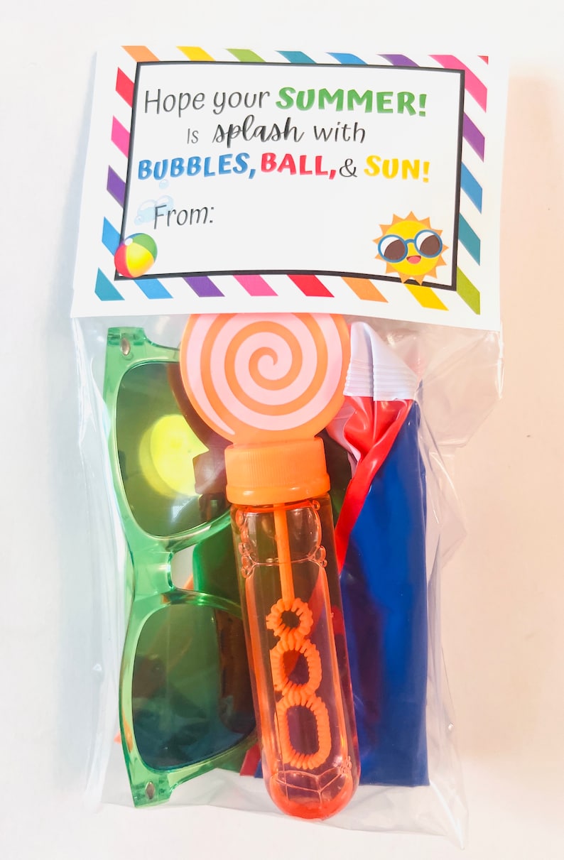 May include: A clear plastic bag filled with summer-themed toys, including sunglasses, a bubble wand, a beach ball, and a lollipop. The bag has a printed tag that says "Hope your SUMMER! Is splash with BUBBLES, BALL, & SUN! From:"