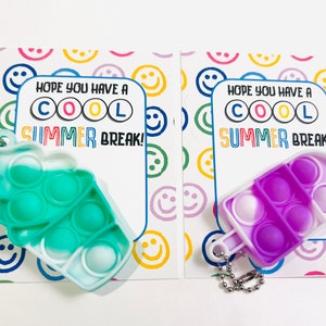 K&ouml;nnte beinhalten: Zwei bunte Pop-it-Fidget-Spielzeuge in Form von Eiswaffeln. Jedes Spielzeug hat einen Schl&uuml;sselanh&auml;nger. Die Spielzeuge befinden sich auf Karten mit dem Text "Ich hoffe, du hast coole SOMMERFERIEN!"