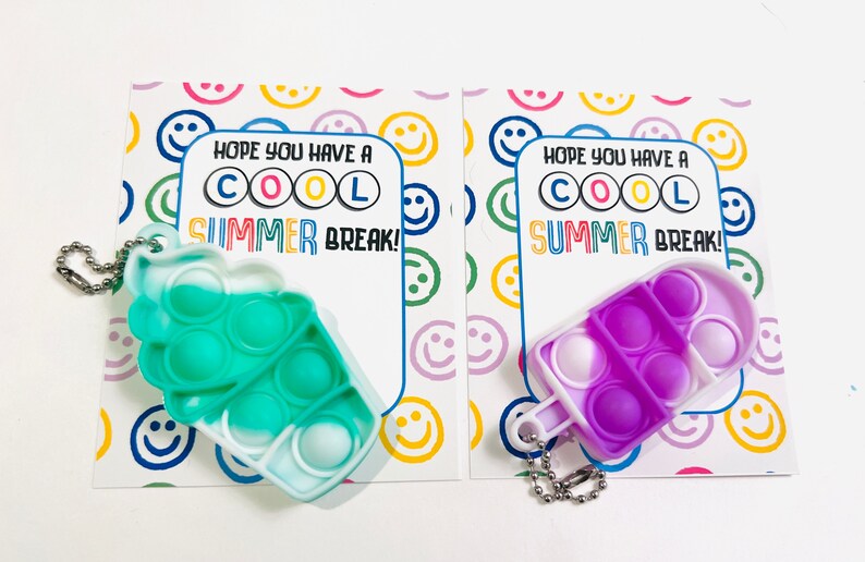 K&ouml;nnte beinhalten: Zwei bunte Pop-it-Fidget-Spielzeuge in Form von Eiswaffeln. Jedes Spielzeug hat einen Schl&uuml;sselanh&auml;nger. Die Spielzeuge befinden sich auf Karten mit dem Text "Ich hoffe, du hast coole SOMMERFERIEN!"