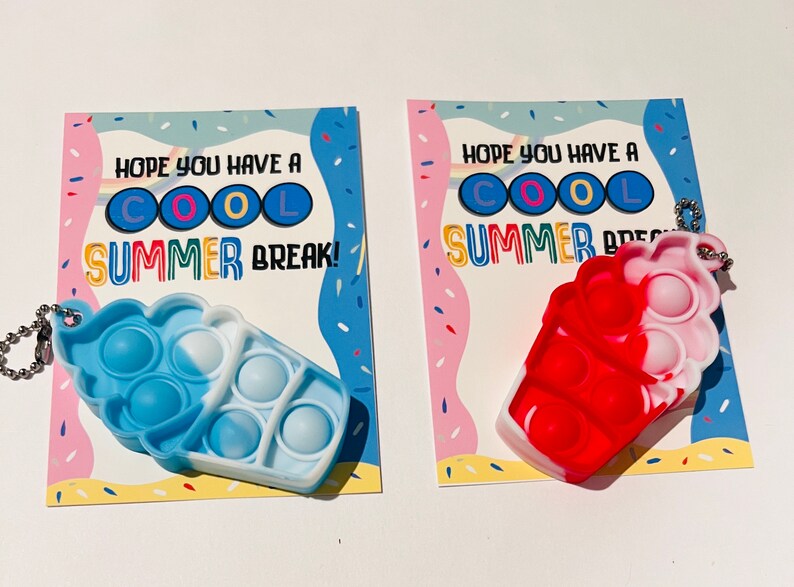 K&ouml;nnte beinhalten: Zwei Karten mit dem Text "HOPE YOU HAVE A COOL SUMMER BREAK!" und einem bunten Hintergrund. An jeder Karte ist ein Pop-it-Schl&uuml;sselanh&auml;nger in Form eines Eisbechers befestigt. Ein Eisbecher ist blau und wei&szlig;, der andere rot und wei&szlig;.