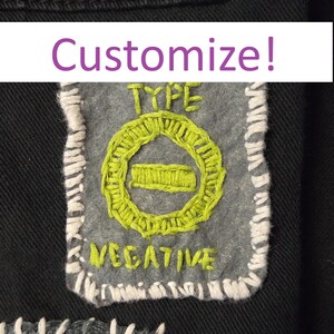 May include: A gray embroidered patch with the words "TYPE NEGATIVE" in green and white thread. The patch has a white stitched border and the word "Customize!" in a purple banner above.