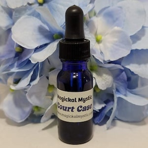 May include: A small blue glass bottle with a black dropper top. The bottle has a white label that reads "Magickal Mystic Court Case" and "www.magickalmystic.com".