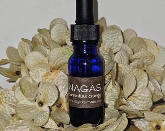 May include: A small blue glass bottle with a black dropper top. The bottle has a brown label with the text "NAGAS Serpentine Energy www.magicalmystic.com".