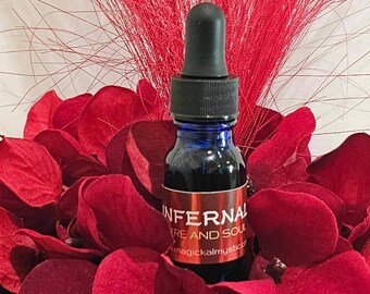 May include: A small blue glass bottle with a black dropper top. The bottle is labelled "Infernal Fire and Soul" with the website "magickalmystical" printed below the label.