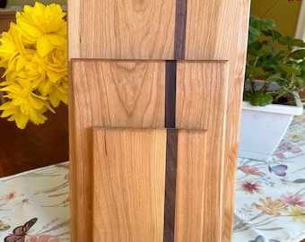 May include: Three wooden cutting boards, nested together, with a dark wood inlay down the center of each. The boards are made of light wood and have a natural finish.