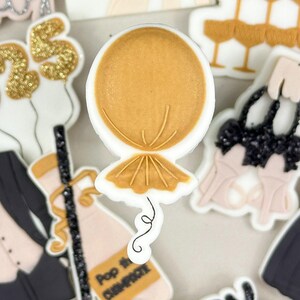 May include: A set of 10 New Year's Eve themed sugar cookie decorations. The decorations include a bottle of champagne, a glass of champagne, a tuxedo, a dress, a balloon, a pair of high heels, a champagne tower, and two signs that say "Happy New Year" and "Happy Party 2025".