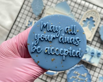 May include: A blue round cookie with gold glitter and the text "May all your duas be accepted".